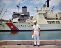 Ken Harbert in uniform in front of Coast Guard ship