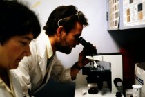 AAPA Promotional Photos - Man Uses Microscope in Background, undated