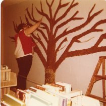 Nadine Walsh paints the paper-mache tree brown