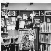 A young patron borrows materials at the circulation desk