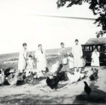 Women feeding Emilie Elftmann's chickens
