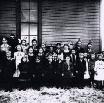 Teacher & children outside a school