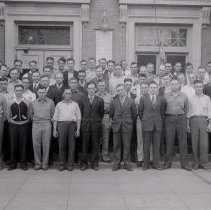 A group of men standing in front of McLeod County  Courthouse