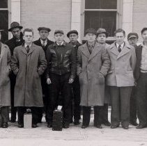 A group of men standing in front of McLeod County Courthouse