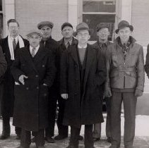 A group of men standing in front of McLeod County Courthouse