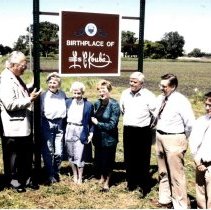 Group posed under the Birthplace of Les Kouba sign