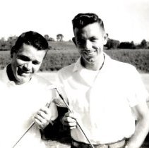 Polariod photo of two men holding golf clubs