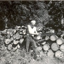 Paul Gaines standing by logs following 1952 Lake Marion tornado
