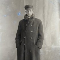 Unidentified man in overcoat and cap