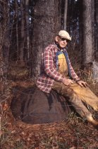 Wilson Rowe sitting on cast-iron tar pot