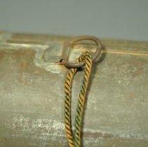 Pivoting hardware ring for the carrying cord