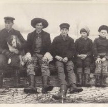 Boys sitting on logs