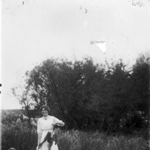 Woman holding a gun and squirrel next to a hunting dog