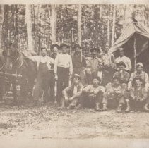 Photo of men in front of tent