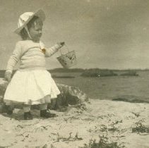 Child with pail at beach