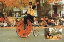 Mr. Pumpkin rides his high-wheeler bicycle in parade