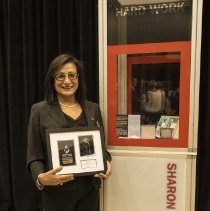 Inductee Sharon Firth posing with her exhibit case