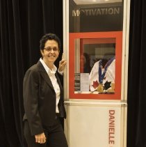Inductee Danielle Goyette posing by her exhibit case
