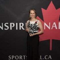 Inductee Cindy Klassen posing with her induction award on the red carpet