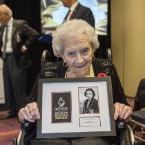 Inductee Kay Macritchie Macbeth holding her framed induction patch