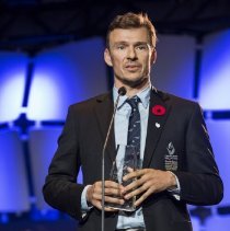 Inductee Simon Whitfield standing onstage at the 2017 induction ceremony