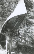 Henry LaPrairie, Jr. portaging a guideboat.
