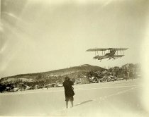 [A sightseeing plane flies over Lake Flower in Saranac Lake, New York.]