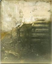 Untitled: Unidentified Man Standing Outside Log Cabin
