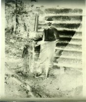 Untitled: Unidentified Man Standing Outside Log Cabin