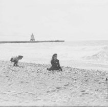 Children playing on the beach in Kincardine, behind them,  the range light.