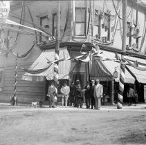 Men standing on decorated street corner on Queen Street, Kincardine.