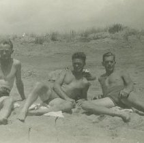 Edmund Fitton Scott and two others lounging on beach