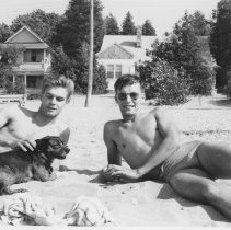 Two men on beach in front of "The Killarney" cottage
