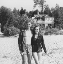 George Gruetzner and woman on beach in front of Laurenhurst cottage