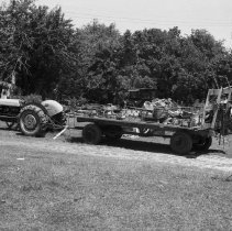 K-74-14-32 Tractor pulling a hay wagon, and other machinery in a farm yard