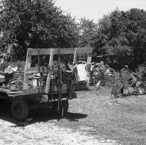 K-74-14-33 Tractor pulling a hay wagon, and other machinery in a farm yard