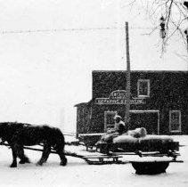 Horses pulling a sleigh in front of J. W. Taylor's business, 708 Queen St.