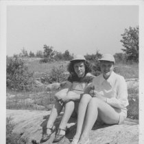Two women seated on large rock