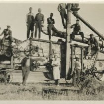 Roy Dickison and men posing on a threshing machine