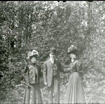 Two ladies and gentleman in wooded area