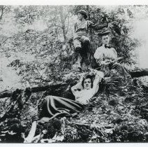 Two young ladies and boy on fallen tree