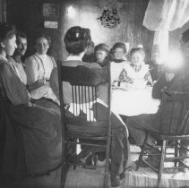 K-81-13-13 Group of people gathered at kitchen table.