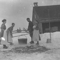 K-81-13-14 Four people standing around a cauldron, during winter.