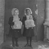 K-81-13-16 Two children wearing winter clothing on a porch.