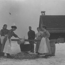 K-81-13-25 Five adults posing around a cauldron by a barn, winter time.