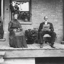 K-81-13-26 Unidentified woman and man sitting on a porch.