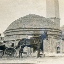 Man in horse drawn buggy outside brick kiln