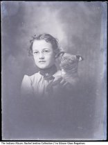 Portrait of a young woman in eyeglasses holding a dog, Greentown, Indiana, 