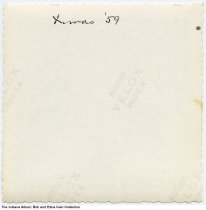 Woman posed with a skillet by a Christmas tree, Indiana, circa 1959