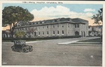 Postcard of exterior of Mercy Hospital building with car on street